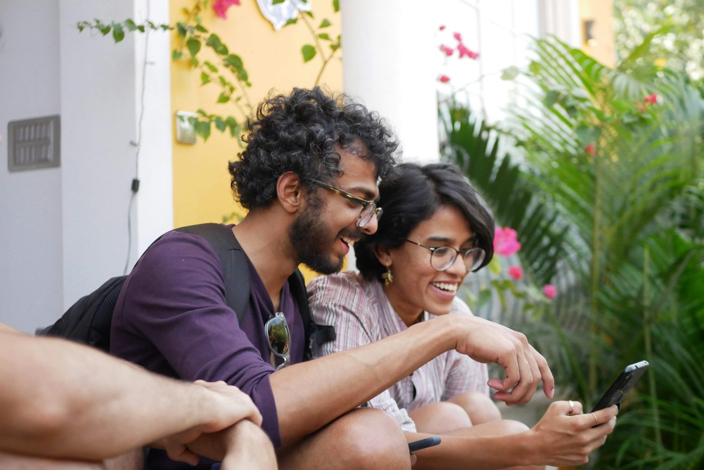 Two friends laughing while looking at a phone together